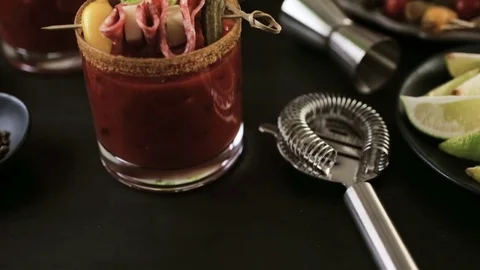 Bloody mary cocktail garnished with celery sticks, olives, and bacon strips. Stock Footage