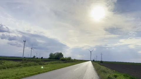 Blooming Rapeseed Field at Sunset With Wind Turbines on Horizon Stock-Footage 335215296