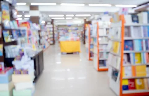 Bloored background of the book store with different books lying on the shelves Stock Photos