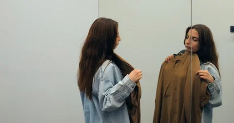Blouse evaluation in dressing room mirror, blouse assessed for fit and fabric Stock Footage 314467202