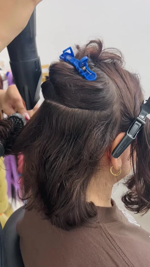 Blow drying hair in salon, vertical view Stock Footage 345135953