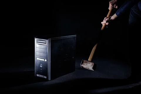 Blow of a heavy hammer onto a desktop computer, isolated, slow motion shot Foto stock