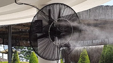 Blower cools hot air around by spraying cold water aerosol Stock Footage 112202092