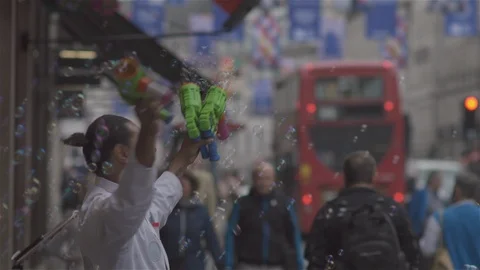 Blowing Bubbles and conducting unseen orchestra in busy city street. Stock Footage 93205992