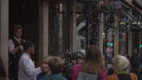 Blowing Bubbles and conducting unseen orchestra in busy city street. Stock Footage 93206009