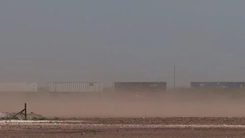 Blowing dust almost obscures passing train in Texas, 4K Stock Footage 243909490