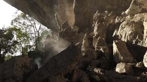 Blowing Fire Smoke in Stone Cave, Sun Light against Texture of Rock Stock Footage 129306206