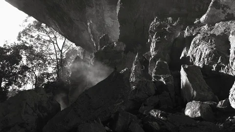 Blowing Fire Smoke in Stone Cave, Sun Light against Texture of Rock Stock Footage 129306379