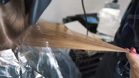 Blowing hair when staining. Drying long brown hair with a hair dryer and a round Stock Footage 79029894