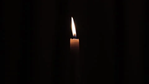 Blowing out candle on a dark background Stock Footage