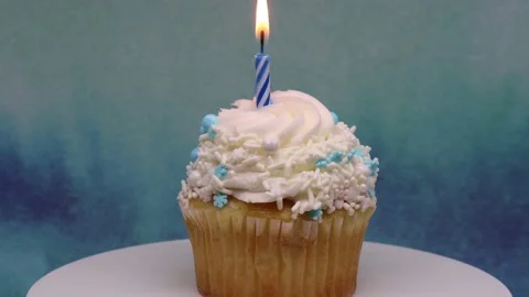 Blowing out candle on rotating cupcake Stock-Footage 238496535