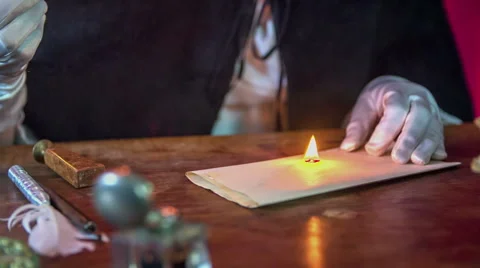 Blowing out the flame on the wax to make a stamp Video stock 49425158
