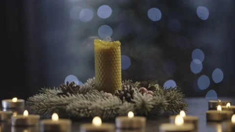 Blowing out a large candle in the rays of small candles. Stock Footage 230703231