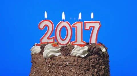 Blowing out new year 2017 candles on a delicious chocolate cake, blue screen Stock Footage 68757860