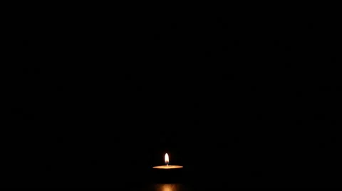 Blowing out the single burning candle in the dark Stock Footage 66675842