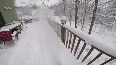 Blowing snow off a deck with a small snow blower. Stock Footage 73025777