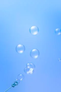 Blowing soap bubbles on blue background Stock Illustration