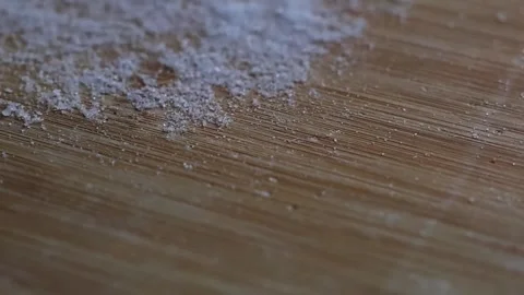 Blowing White Salt or Flour Off a Wooden Cutting Board in Slow Motion Video stock 329556167