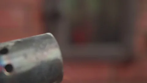 Blowtorch is lit on blurred red background Stock Footage 77083529