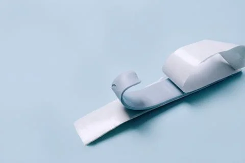 Blu Tack in a shape of thin flat strip on blue background Stock Photos