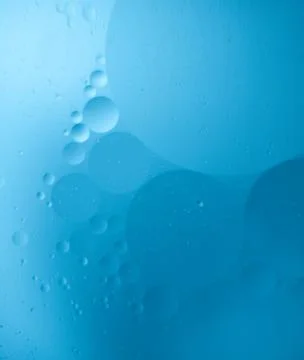 Blue abstract background with floating translucent oil bubbles in water Stock Photos
