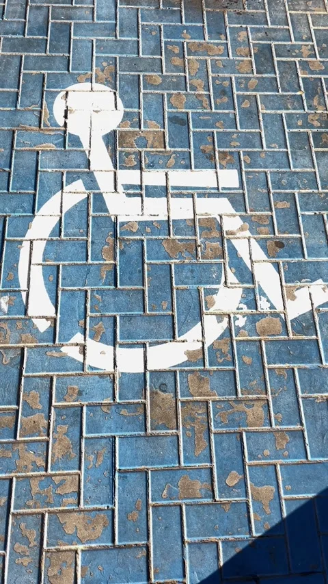 Blue accessible parking space on patterned pavement Stock Footage 342817116