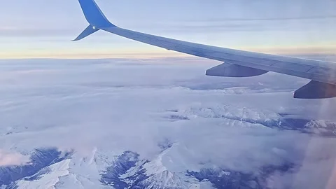 A blue airplane wing is flying through a cloudy sky 库存影片 276310054