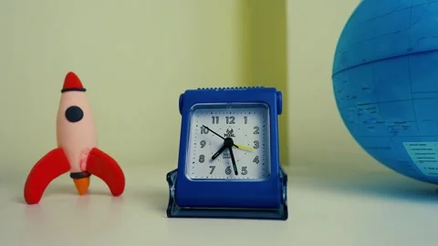 Blue Alarm Clock with Toy Rocket and Globe Video stock 317737100