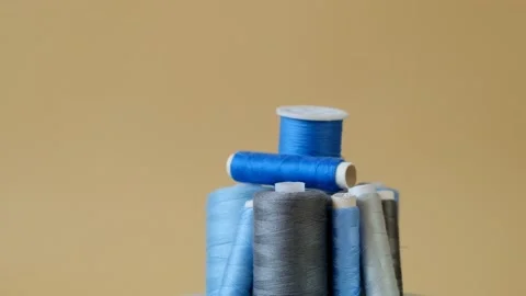 Blue and gray threads set on a beige background.Sewing and handicraft concept. Stock Footage 158230832