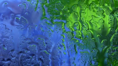 Blue and green defocused view through wet window. Stock Footage 98680415