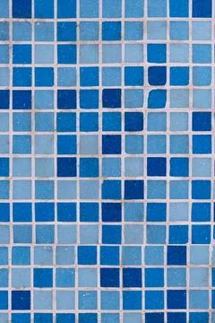 Blue and light blue square ceramic tiles forming an abstract grid pattern w.. Stock Photos