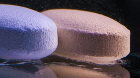 Blue and orange pills dissolve on black background. Macro Close up. Vídeo Stock 119061601