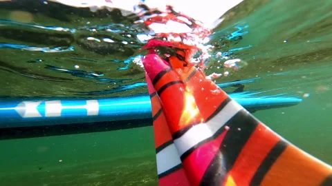 Blue And Patterned Oar And Paddleboard Seen Floating On River - Delta Junction, Stock Footage 233998556