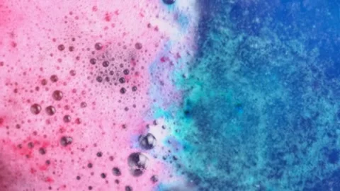 Blue and pink bath bomb balls dissolves in water with bright cobalt blue an.. Stock Footage 273677451