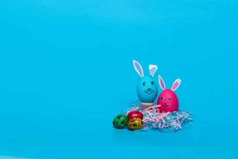 Blue and pink Easter eggs in the form of a hare on a blue background Stock Photos