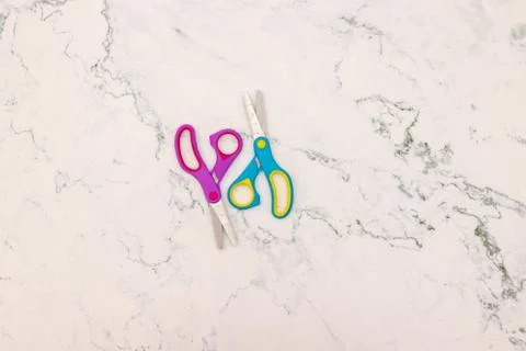 Blue and pink scissors on the table Stock Photos