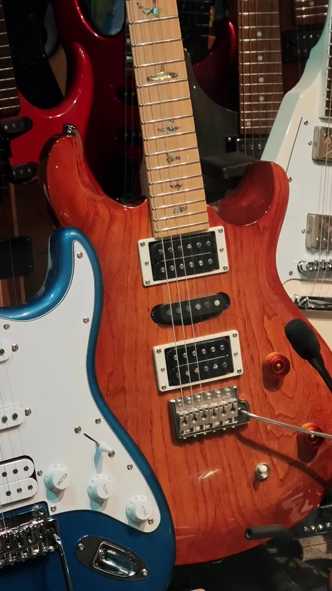 Blue and red electric guitars displayed in local musical instrument shop Stock Footage 334633575