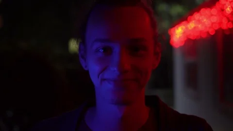 Blue and red light on young men's face outdoors at night 2 Stockbeeldmateriaal 95861960