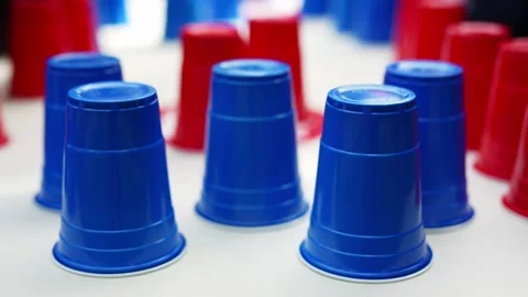 Blue and red plastic cups upside down on white surface Stock Footage 335010781
