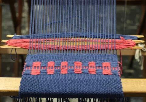 Blue and red threads in the weaving machine Stock Photos