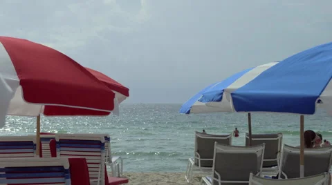 Blue and red umbrellas facing the pacific ocean, Miami Beach Stock Footage 65829439
