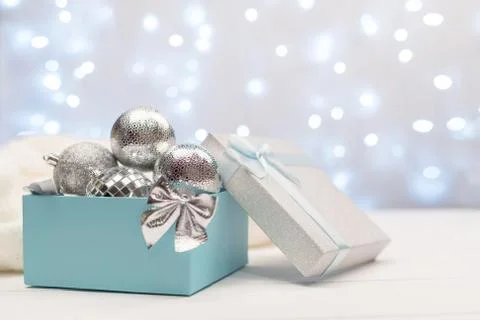 Blue and silver box with silver Christmas balls on the background of blue bok Stock Photos