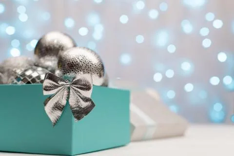 Blue and silver box with silver Christmas balls on the background of blue bokeh Stock Photos