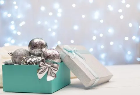 Blue and silver box with silver Christmas balls on the background of blue bok Stock Photos