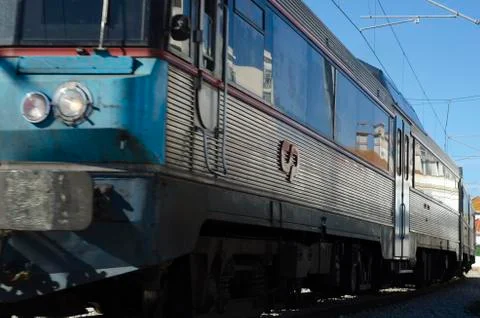Blue and silver train against a blue sunny sky. Stock Photos