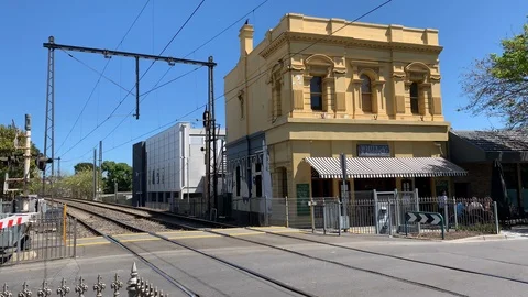Blue and silver train crosses a street in Melbourne Video stock 97919595