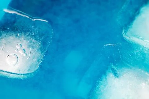 A blue and white background with ice cubes in the foreground Stock Photos