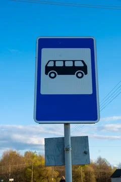 Blue and white bus stop road sign against blue sky Stock Photos