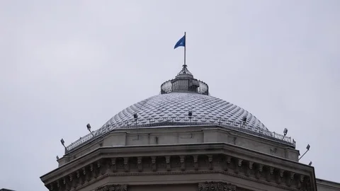 The blue and white CIS flag on the dome of the building develops in the wind 스톡 동영상 84953045