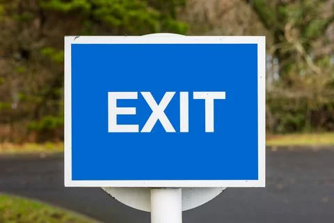 Blue and white exit sign on white post outdoors Stock Photos